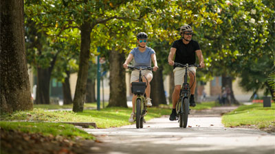 Una pareja recorre un parque con sus bicicletas plegables Cube.