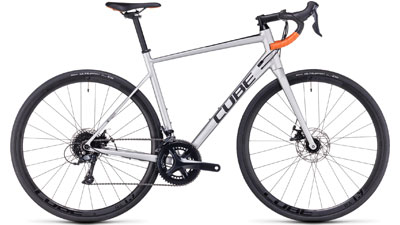 Bicicleta de carretera Cube Attain Pro en color plata con manillar drop bar naranja.