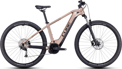 Se puede ver una bicicleta híbrida Cube Reaction en color oro rosa.