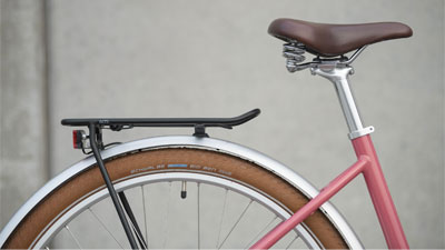 Se puede ver una foto posterior del portaequipajes y el sillín de una bicicleta eléctrica Cube Ella Hybrid.