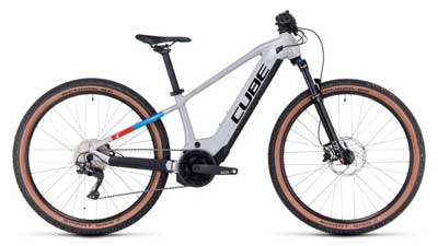 Se puede ver una bicicleta Cube Reaction Hybrid blanca para niños con detalles en azul y rojo.
