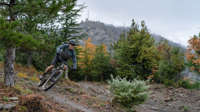 Ciclista montando una bicicleta de montaña Cube Stereo MTB DE DOBLE SUSPENSIÓN en el bosque.