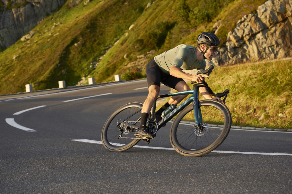 Ciclista de Gravel en bicicleta deportiva en una carretera de montaña